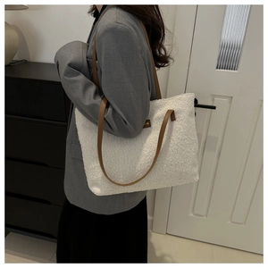 Dettaglio della borsa tote in peluche bianca con tracolla in pelle marrone