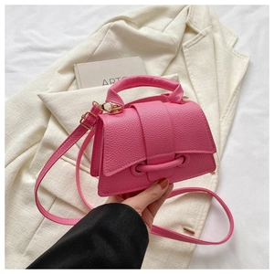 Detailaufnahme der rosa Kunstledertasche mit Lychee-Struktur und Klappverschluss