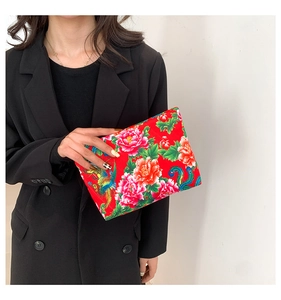 Detail of red nylon clutch featuring traditional Chinese floral peony and phoenix patterns