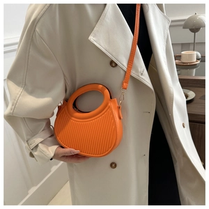 Chic orange dumpling bag featuring vertical pleats and round handle for women