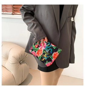 Dettaglio della pochette con ricami tradizionali di peonie rosse e motivi di fenice