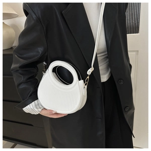 Detail of white pleated crescent bag texture on model with adjustable strap