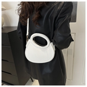 Detail of white dumpling handbag featuring pleated texture and round handle on a model