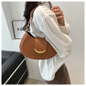 Detail of caramel brown crescent shoulder bag with a gold crescent metal buckle