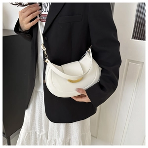 Close-up of a white crescent saddle bag with gold metal buckle on a model shoulder