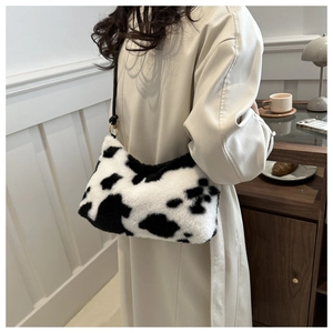 Detail of soft faux fur shoulder bag with cow print pattern and elegant black strap