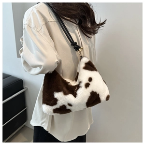 Detail of plush faux fur shoulder bag with cow print and black knotted leather strap
