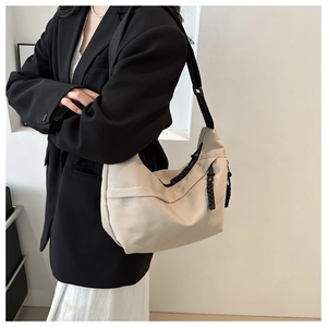 Detail of minimalist cream canvas hobo bag with contrast black rope zipper and wide strap