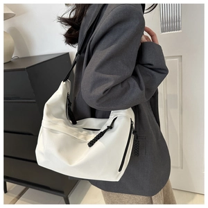 Side view of white canvas hobo bag showing large capacity and black zipper details