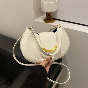 Minimalist white leather crescent shoulder bag with elegant gold crescent buckle detail