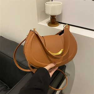 Vintage brown leather half-moon saddle bag with elegant gold crescent metal buckle