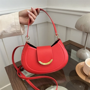 Red leather crescent shoulder bag with gold metal buckle and adjustable straps