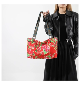 Détail du sac cabas rouge à motifs floraux avec une large bandoulière style ethnique