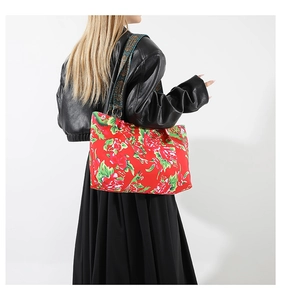Sac cabas rouge à fleurs avec bandoulière ethnique porté par un mannequin