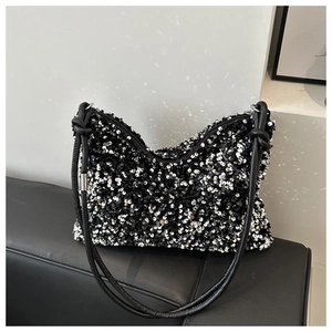 Detail showing shiny silver sequins, zipper top and knotted strap on black hobo shoulder bag
