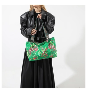 Détail du sac cabas vert à fleurs avec bandoulière ethnique tissée et anneaux métal