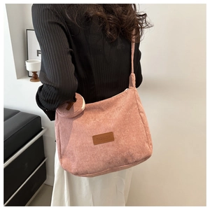 Detail of pink corduroy tote bag with round coin purse and leather fashion patch