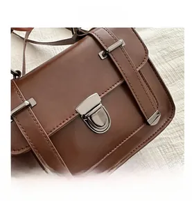 Dettaglio borsa a tracolla in pelle marrone scuro con fibbia vintage e cuciture rifinite