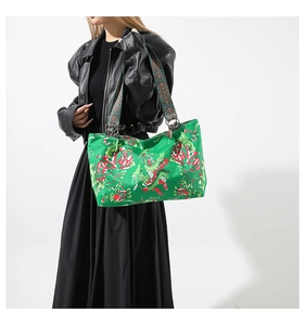 Sac fourre-tout vert tendance avec motifs floraux rouges et large bandoulière tissée