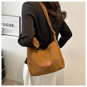 Close-up of caramel corduroy tote bag featuring a leather fashion label and mini round pouch