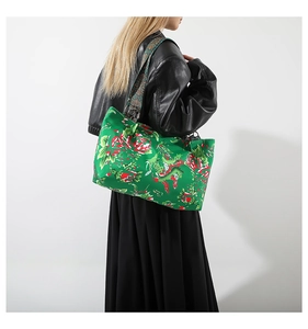 Détail du sac cabas vert à imprimé dragon avec large bandoulière à motifs variés