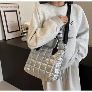 Vue détaillée du sac cabas matelassé argenté avec texture rembourrée et sangle noire