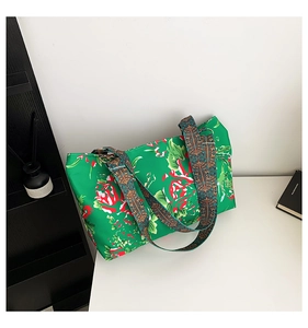 Détail du sac à fleurs vert avec sangle ethnique et anneaux dorés en gros plan