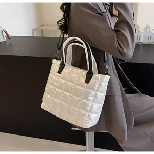 Détail du sac fourre-tout matelassé blanc avec poignées noires et bandoulière