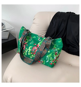Détail du sac cabas vert à motifs floraux et dragons avec bandoulière ethnique large