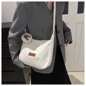 Detailed shot of white corduroy tote bag with fashion leather tag and round coin purse