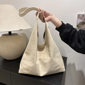 Minimalist beige suede tote bag with large capacity for women on a dark shelf