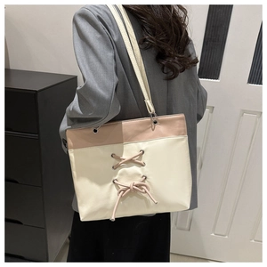 Détail d'un grand cabas bicolore crème et rose avec rubans croisés décoratifs
