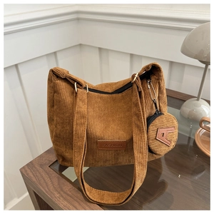 Close-up of brown corduroy tote bag with FASHION leather patch and small round coin purse