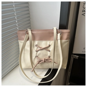 Détail du sac cabas rose et beige avec lacets style corset et œillets métalliques