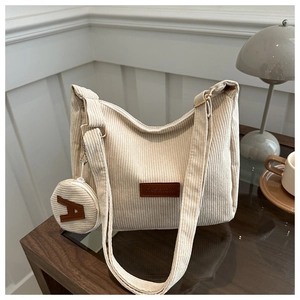 Close-up of cream corduroy tote bag with small round pouch and fashion leather patch