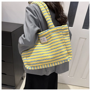 Detail of plush tote bag showing yellow and blue stripes with fan fan porty leather patch