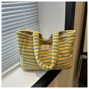 Gros plan du sac fourre-tout en laine d'agneau à rayures jaunes et bleues avec patch