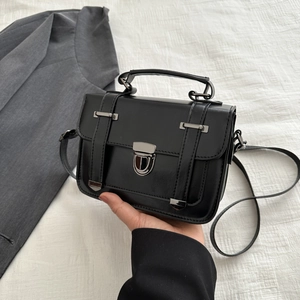 Dettaglio della borsa a tracolla vintage in pelle PU nera opaca con fibbia in metallo