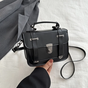 Dettaglio di una borsa a tracolla vintage nera con fibbia argento e finitura opaca