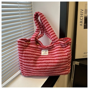 Detailansicht der gestreiften Lammwoll-Tasche mit weicher Textur und gewebtem Logo-Etikett
