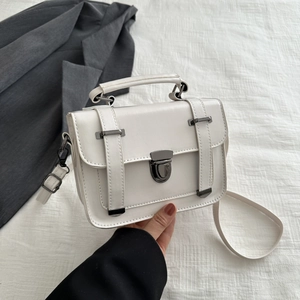 Dettaglio della borsa a tracolla beige vintage con fibbia in metallo e pelle liscia