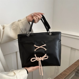 Sac cabas noir en cuir avec laçage en ruban rose et œillets métalliques argentés