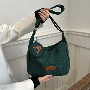 Dark green corduroy tote bag with fashion patch and a small round coin purse charm