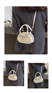 Detailed view of cream leather handbag with silver chain and rivet accents on the zipper