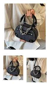 Close-up of Y2K grey denim bowling bag featuring silver chain decor and black leather handles