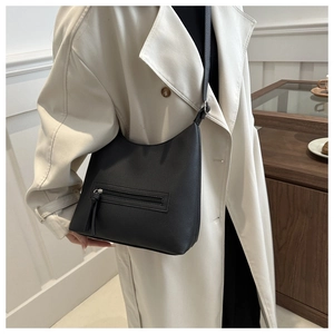 Detail shot of black hobo bag showing lychee grain leather texture and front zipper