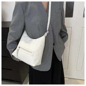 Detail of white lychee texture tote bag featuring long tassel zipper pocket and slim strap