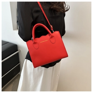Detail of red wavy-edge crossbody bag with gold Fashion & Bags lettering print