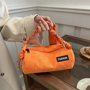 Orange corduroy barrel crossbody bag with fashion label and woven rope strap
