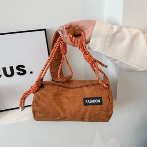 Brown corduroy cylindrical crossbody bag with vibrant orange woven rope shoulder strap